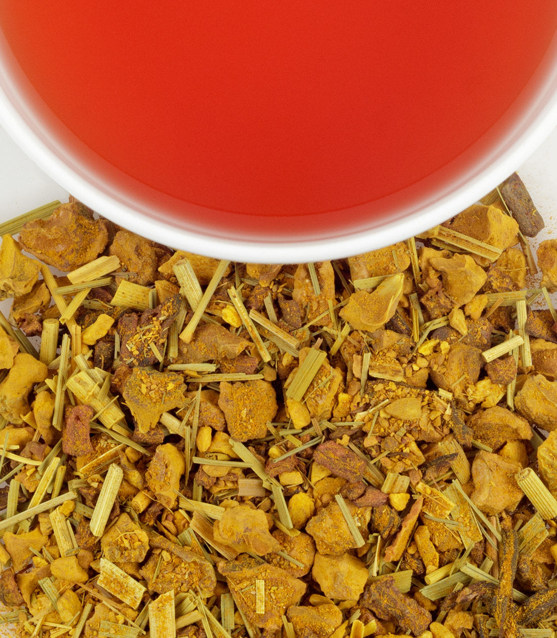 Turmeric ginger tea blend with dried herbs and a cup of vibrant red tea above. Contains 9 MG CBD for relaxation.