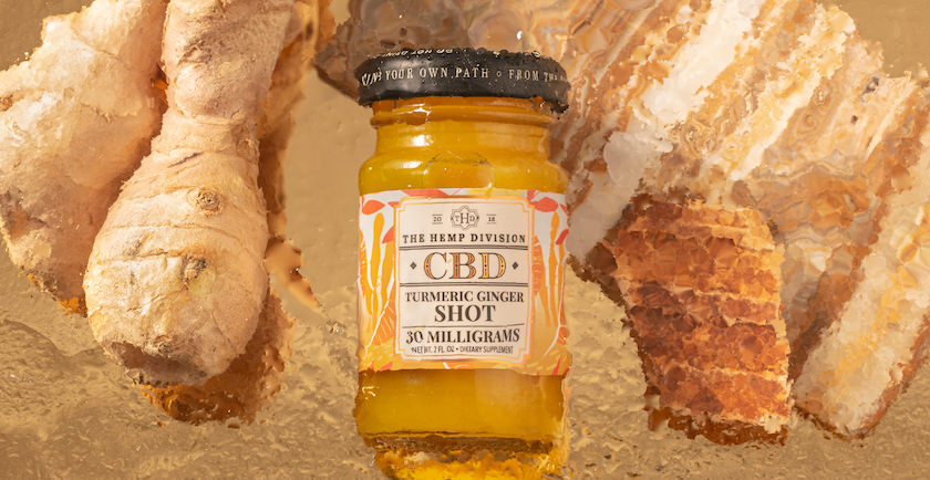 Tumeric Ginger Shot with ginger root in the background.