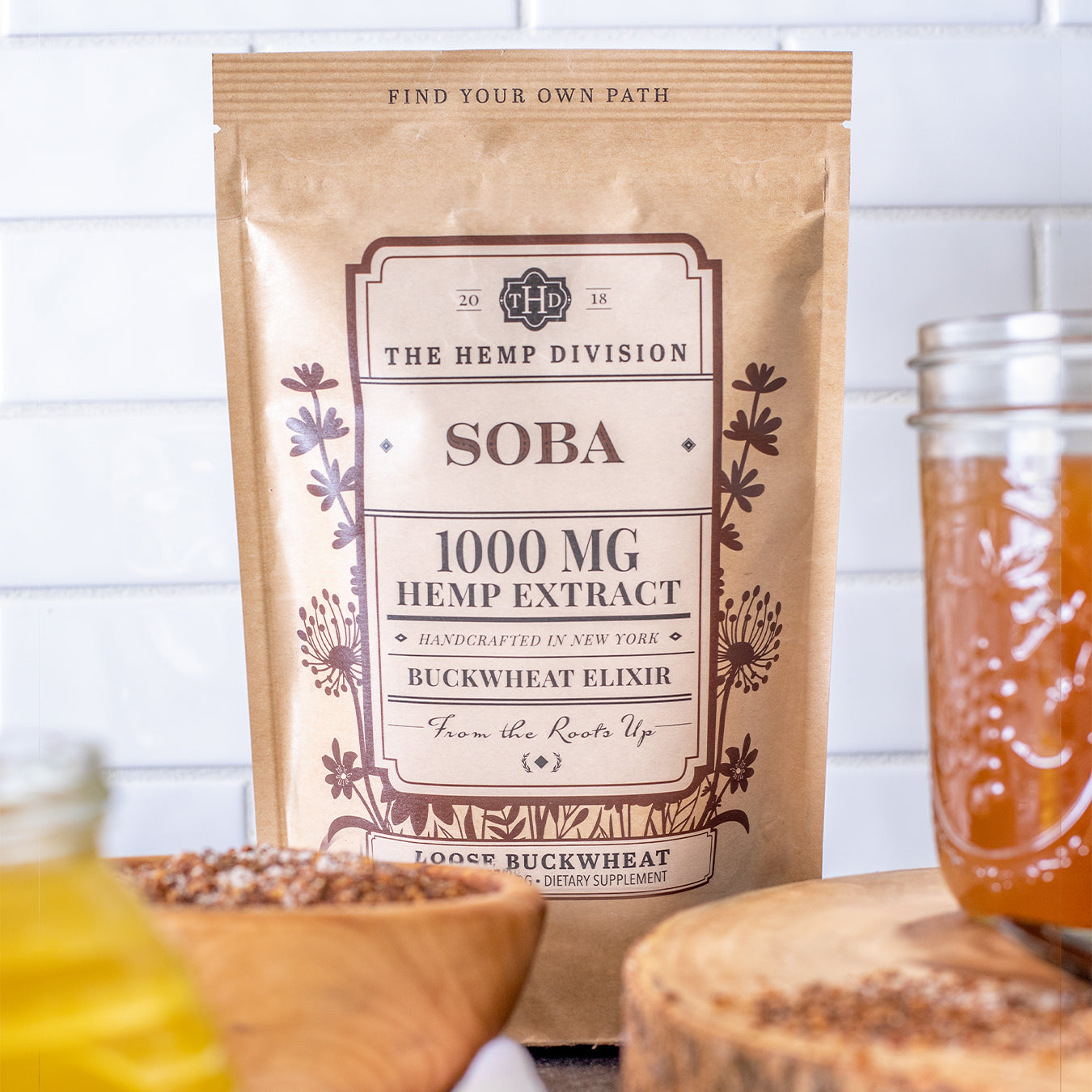 Soba Elixir 1,000 MG CBD packaging on a kitchen counter, featuring natural ingredients and a rustic aesthetic.