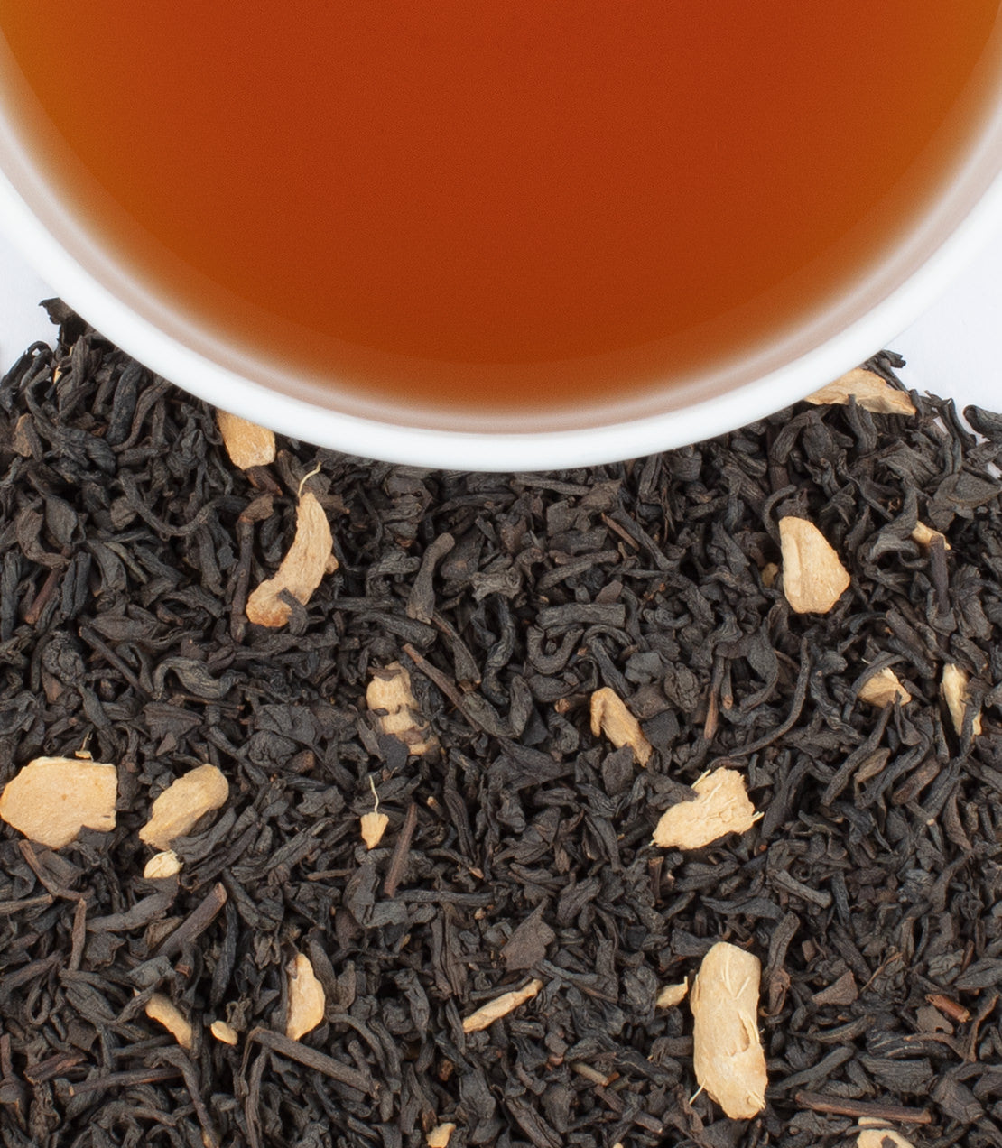 Gingerbread tea blend with 20 MG CBD, featuring black tea leaves and ginger pieces, in a white cup.