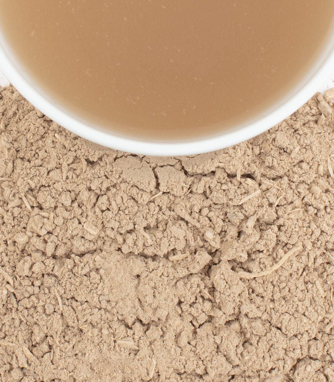 Kava root powder with a cup of kava drink, showcasing its earthy texture and calming beverage.